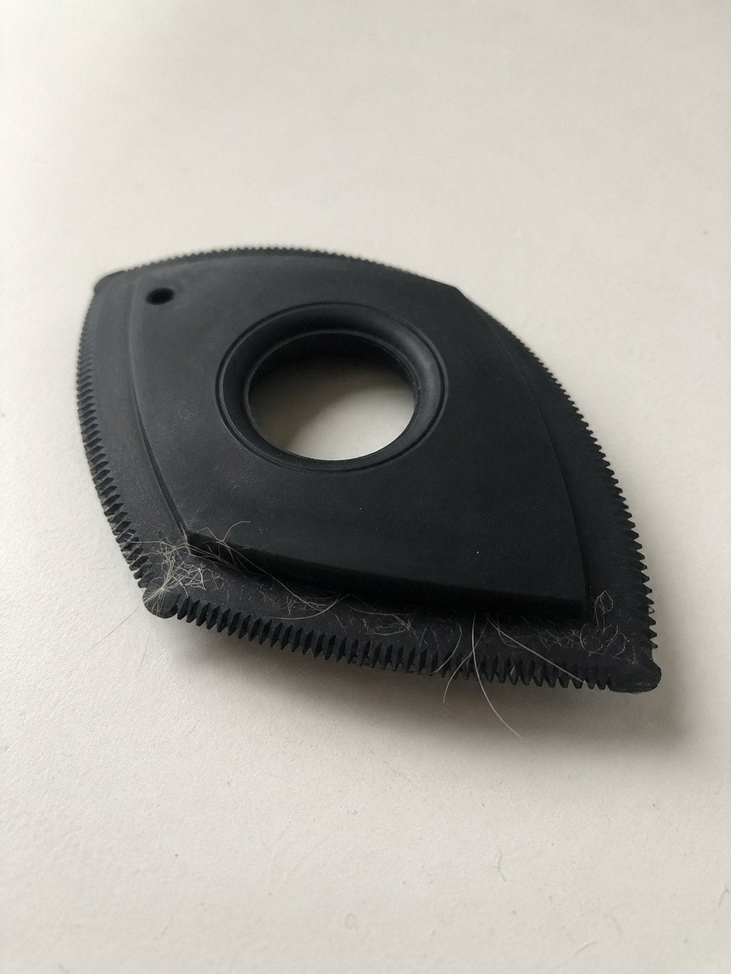 The Furget It car pet-hair tool — black rubber tool with a toothed silicone edge, fur caught in the teeth