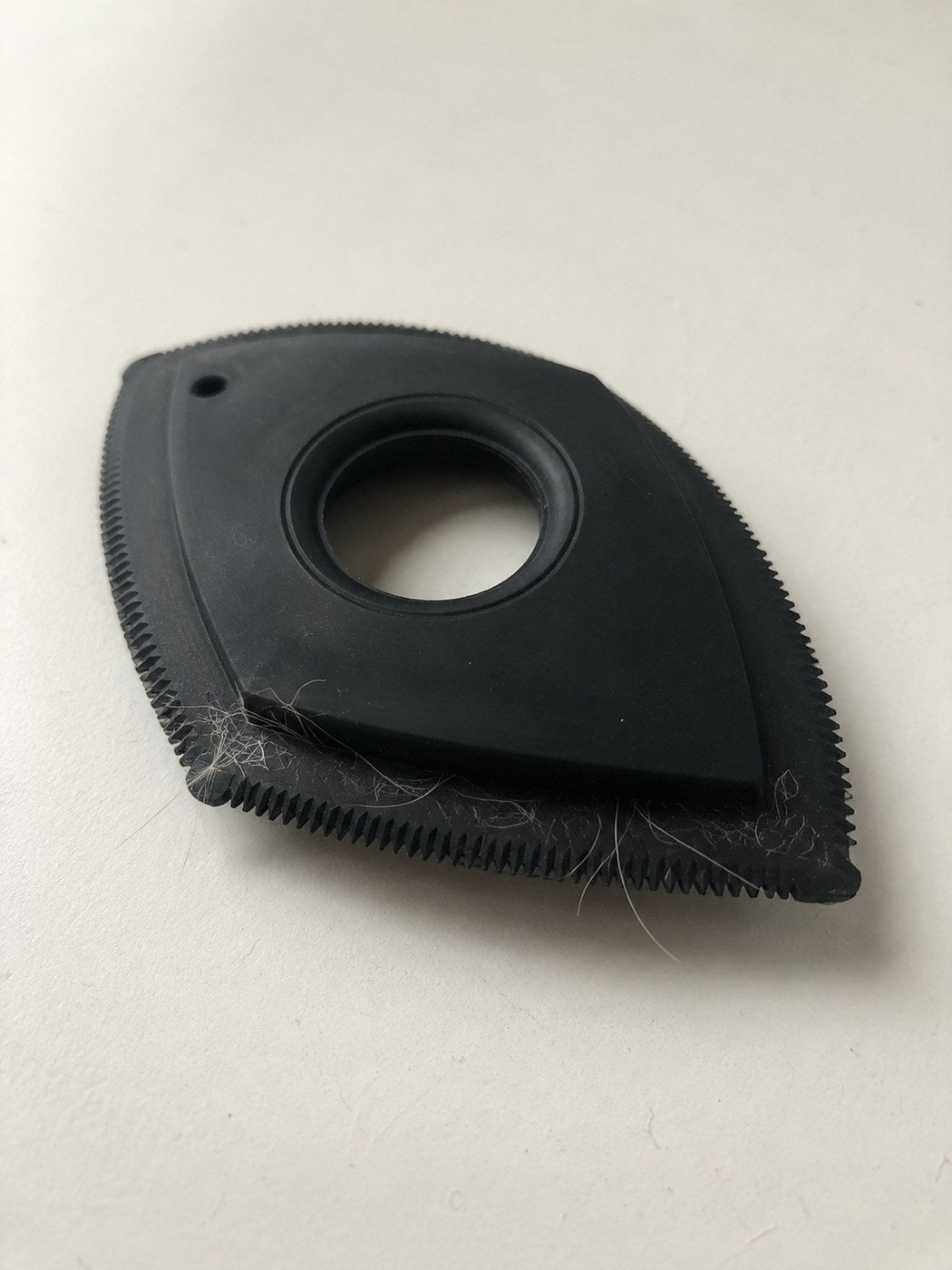 The Furget It car pet-hair tool — black rubber tool with a toothed silicone edge, fur caught in the teeth